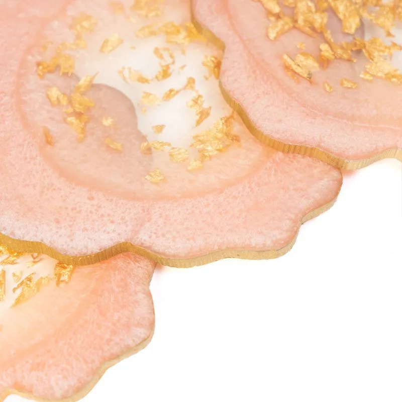 Close-up of overlapping peach-pink coasters with gold detailing