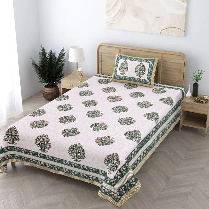 Angled view of pink printed bedsheet with green border on a single bed
