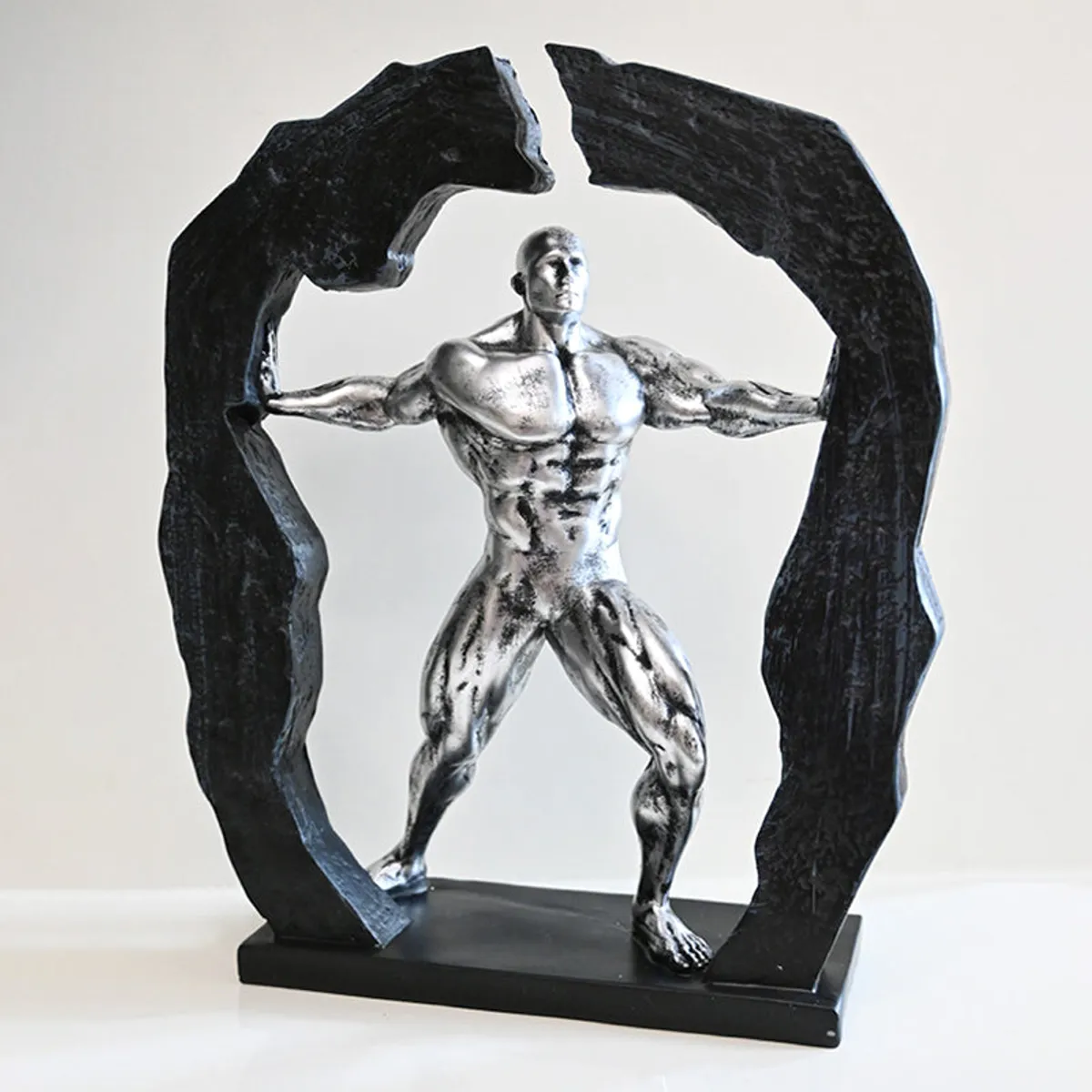 Front view of silver figurine showpiece with textured black arch-like frame