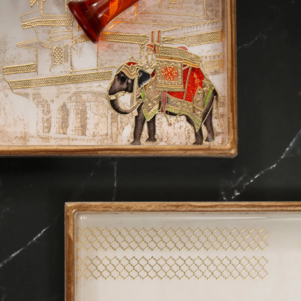 Close-up of palace and elephant artwork on a square serving tray