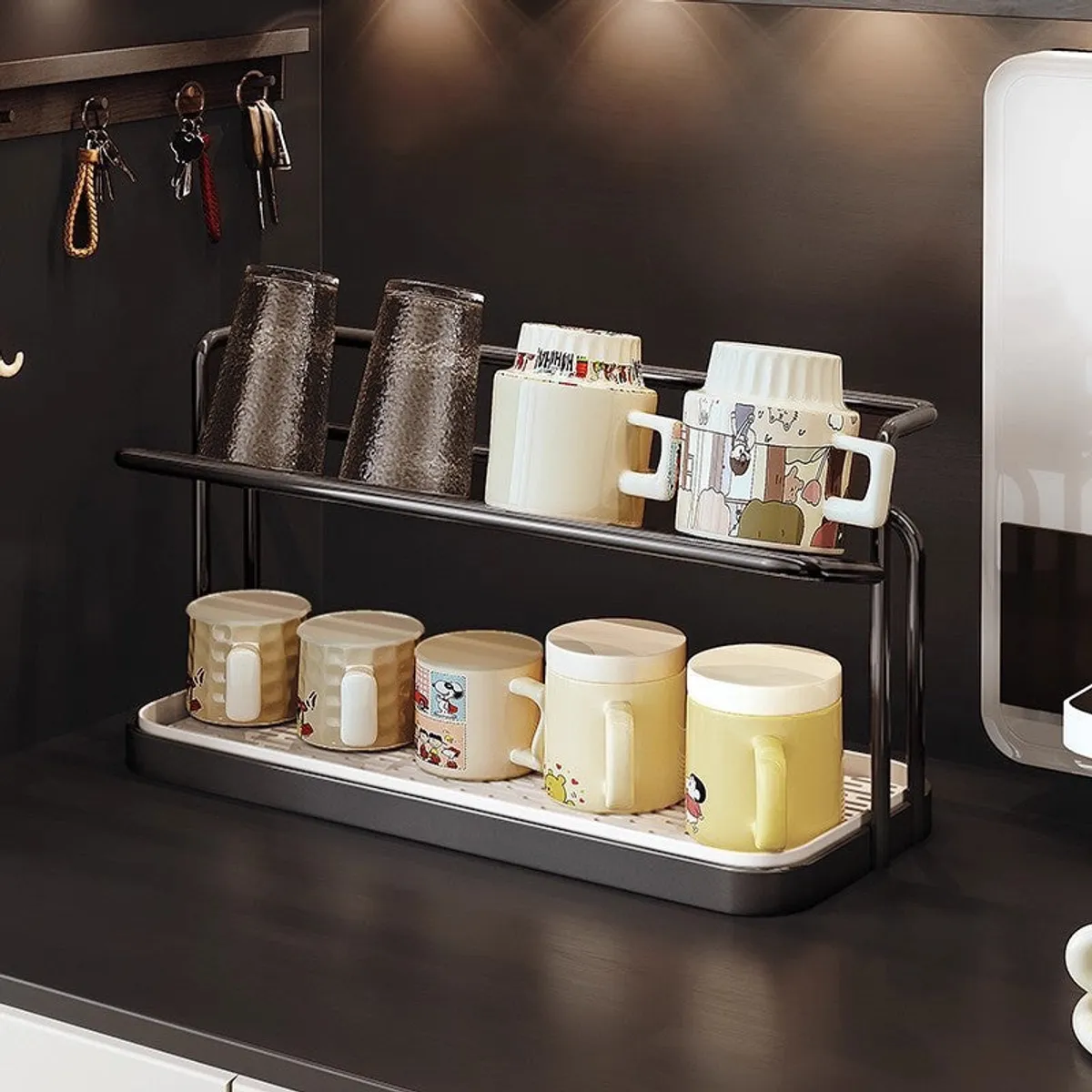 Black two-tier cup rack with mugs and glasses placed on a dark countertop