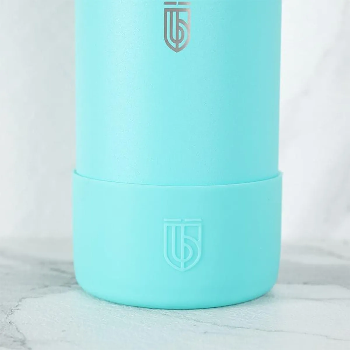 Close-up of the sky-blue bottle showing its matte cylindrical finish
