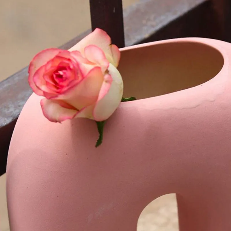 Close-up of the top opening of a pink ceramic arc vase