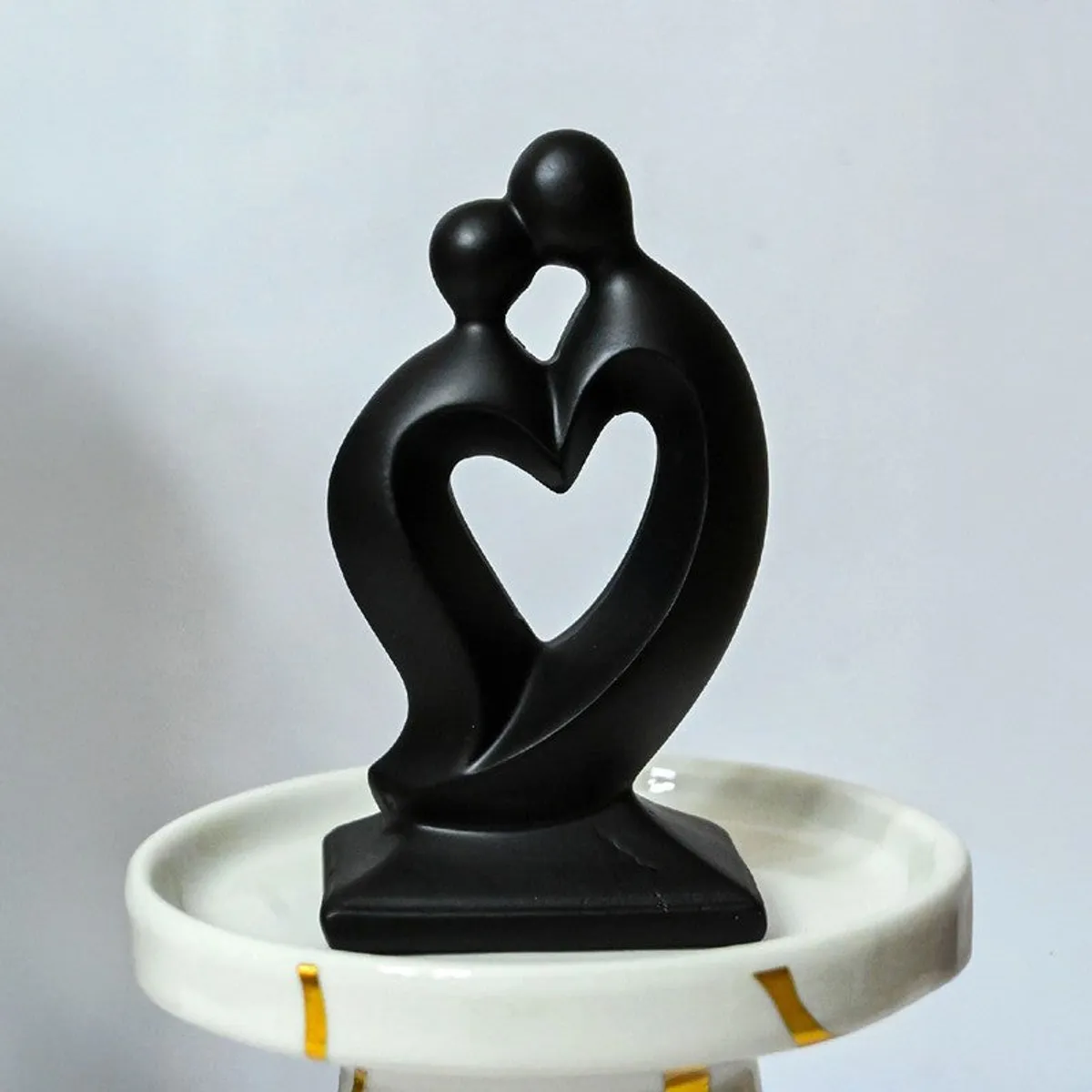 Black abstract couple showpiece displayed on a round white pedestal tray