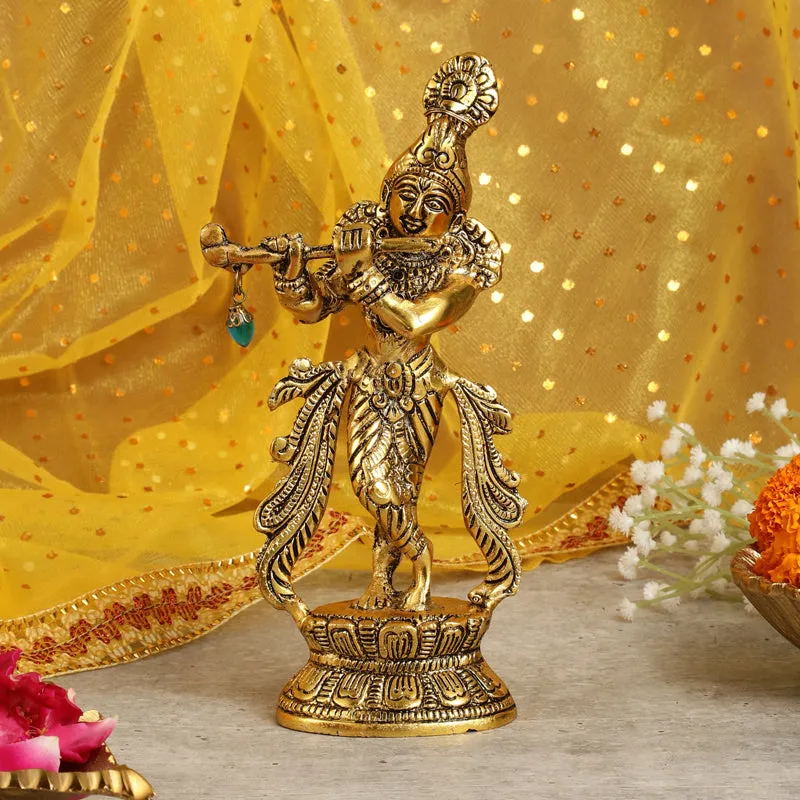Close-up of a gold-toned Lord Krishna idol with ornate detailing