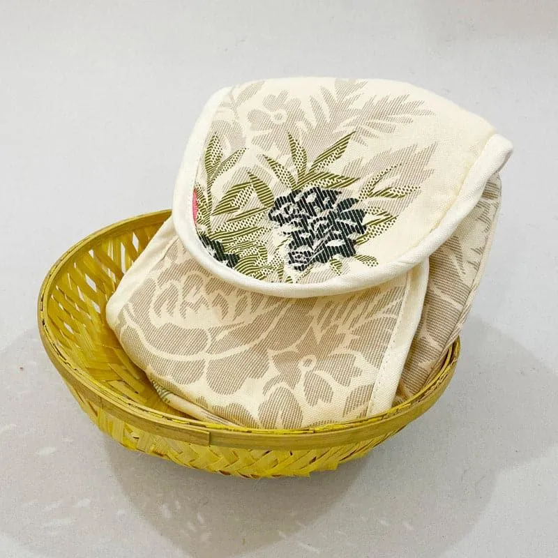 Yellow basket holding a white floral cotton bread cover