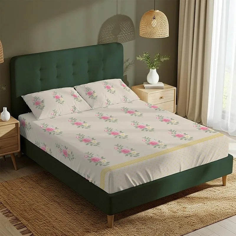 Light pink floral bedsheet with matching pillow covers on a green upholstered bed