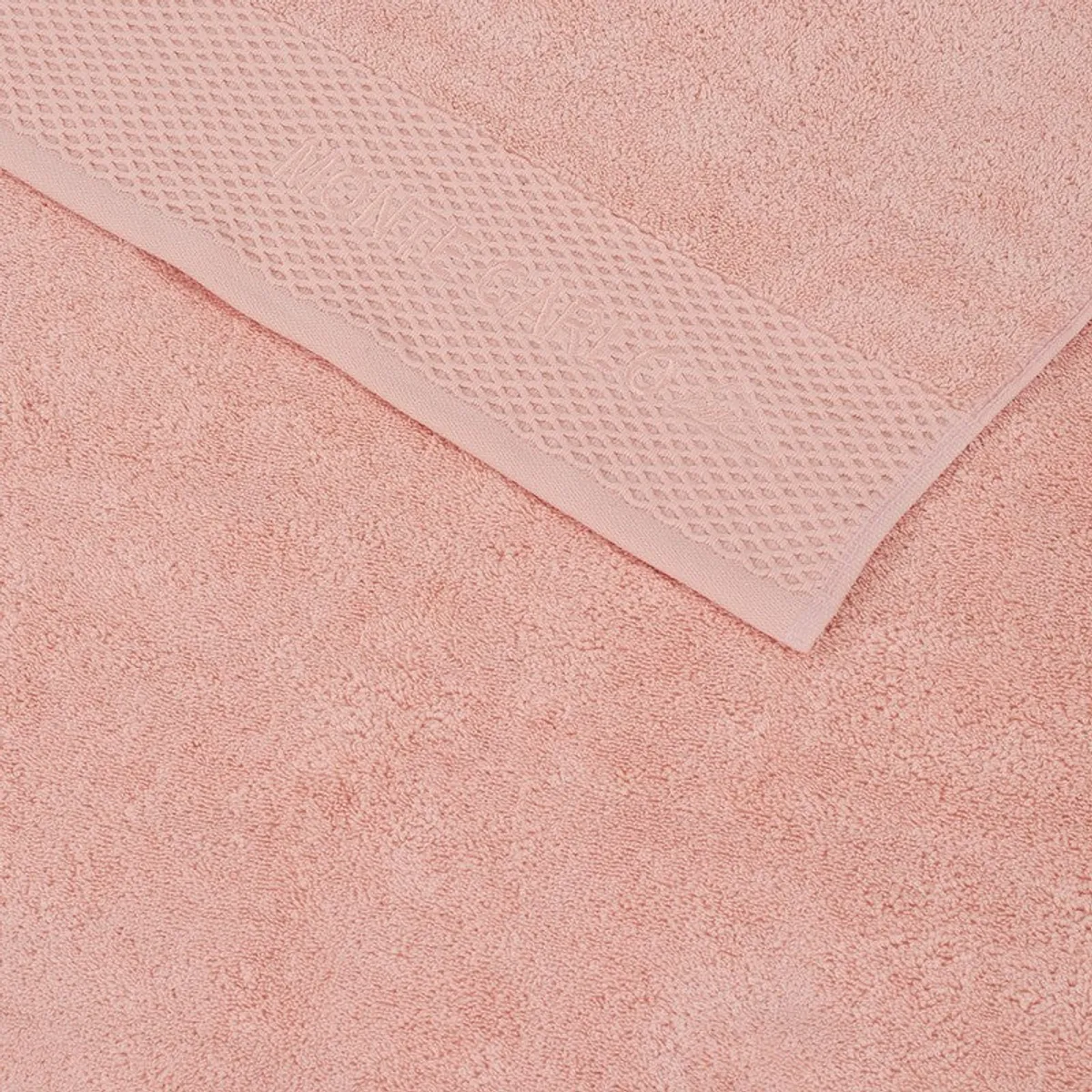 Close-up of the towel's textured decorative border and pink cotton surface