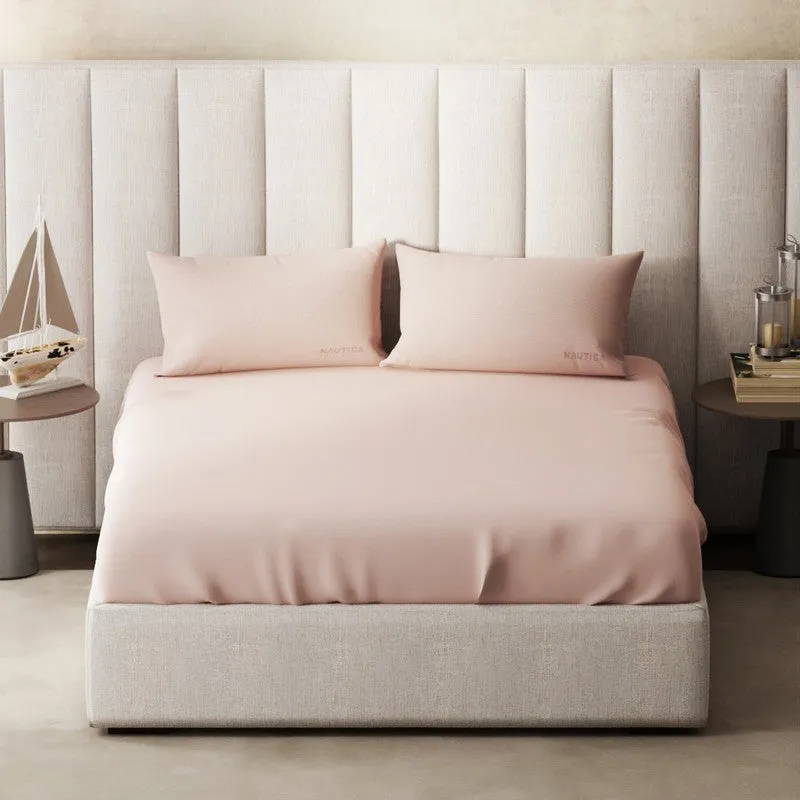 King-size pink bedsheet styled across a bed with two matching pillows