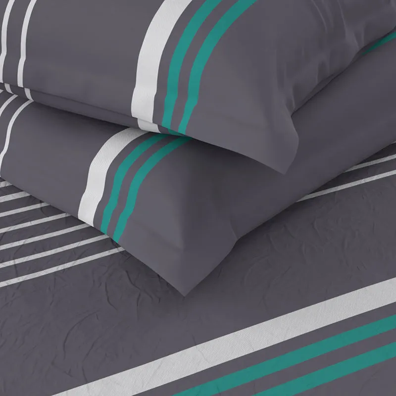 Folded grey pillow covers and bedsheet with white and teal stripe detail