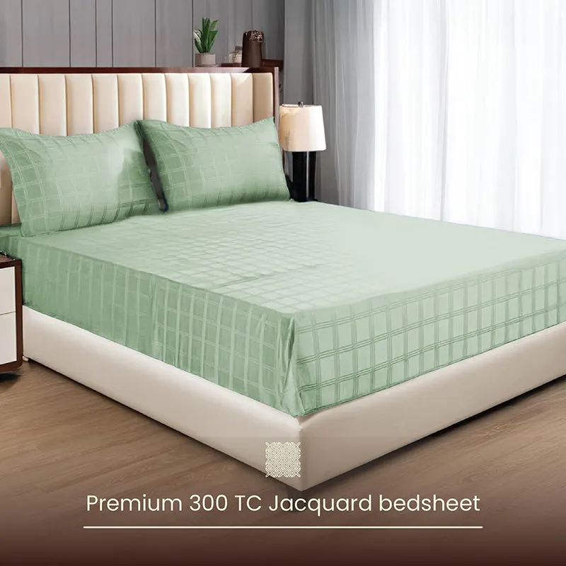 Sage green checked bedsheet spread on a bed with matching pillow covers
