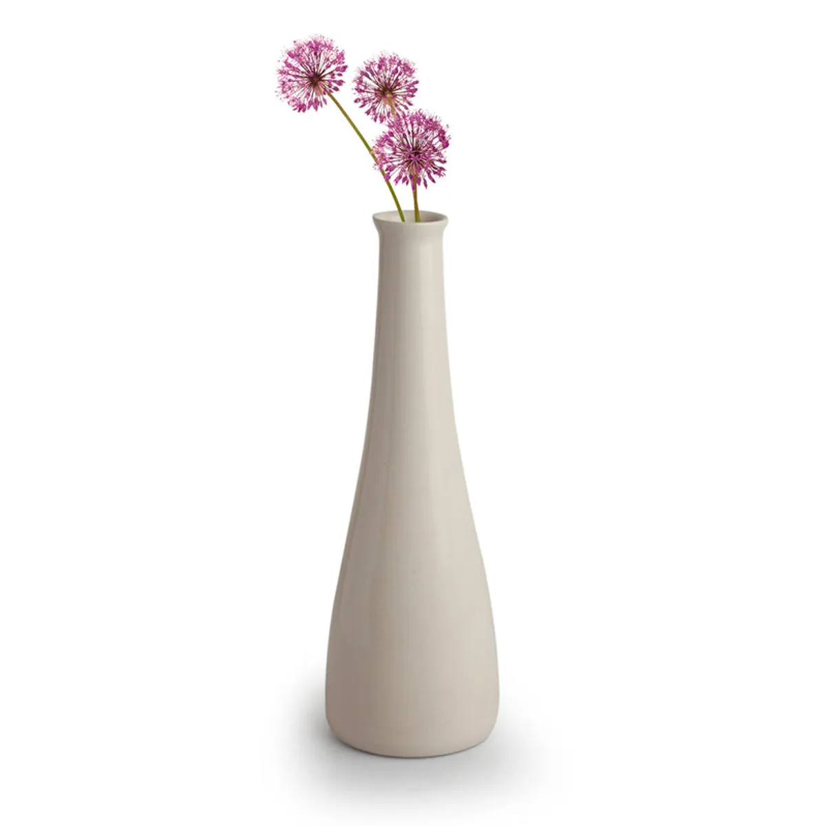 Tall white ceramic bottle vase with purple flowers on a plain background