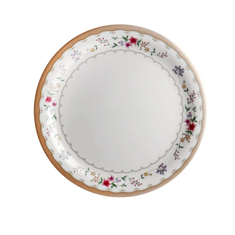 Round white dinner plate with a floral border and scalloped brown rim