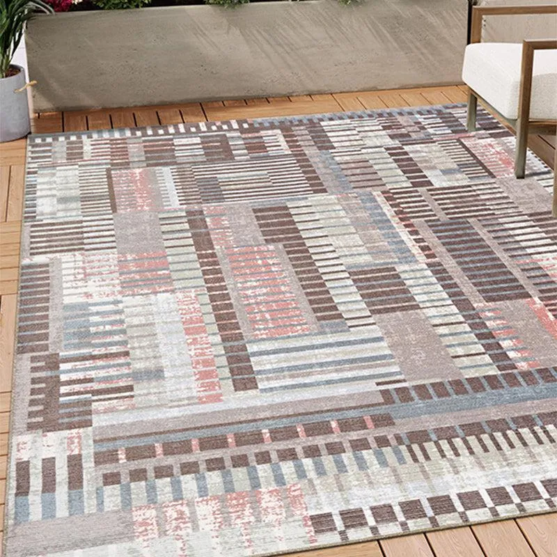Abstract rectangular carpet in brown, blue and pink tones styled outdoors