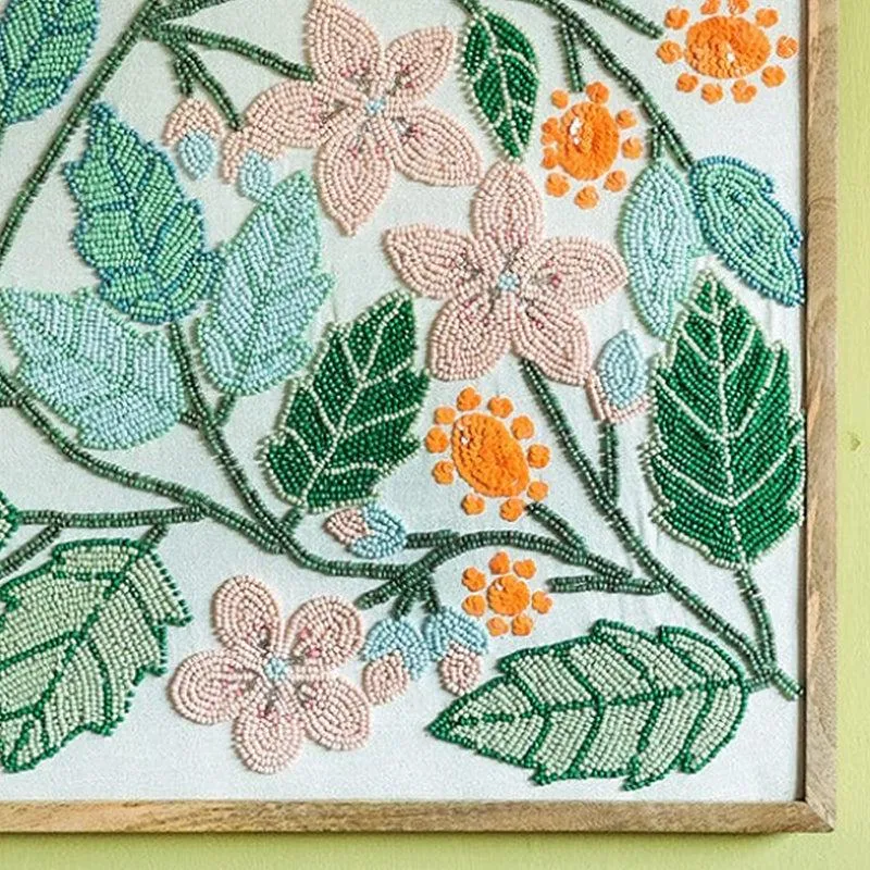 Close-up of colourful beaded flowers and leaves on the framed wall accent