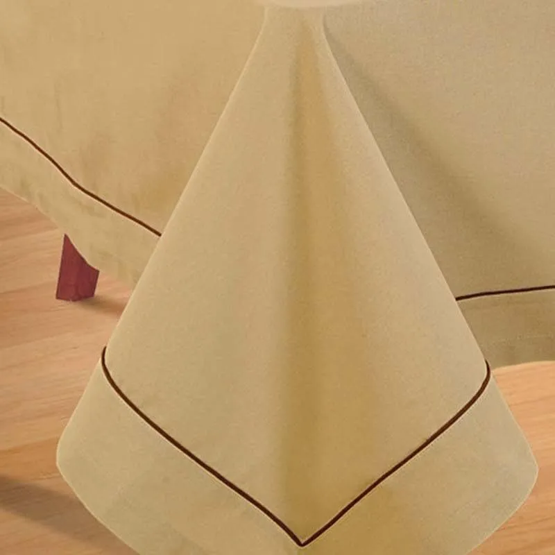 Close-up of a beige table cover corner with a thin brown border