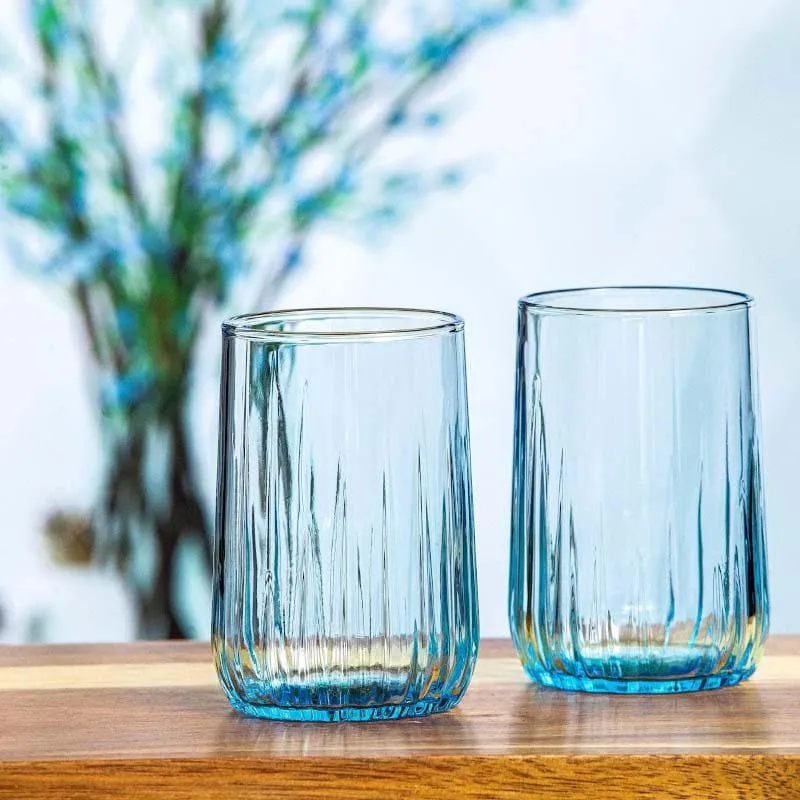 Two blue tinted tumblers placed on a wooden tabletop