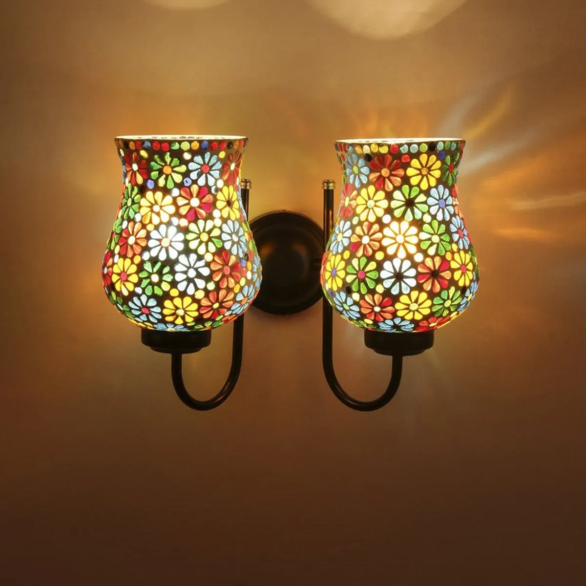 Close front view of the lit twin floral tulip mosaic wall lamp