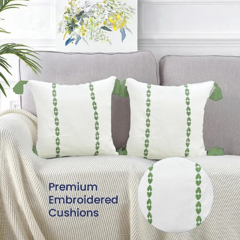 Two white and green cushion covers styled on a grey sofa with a close-up fabric inset