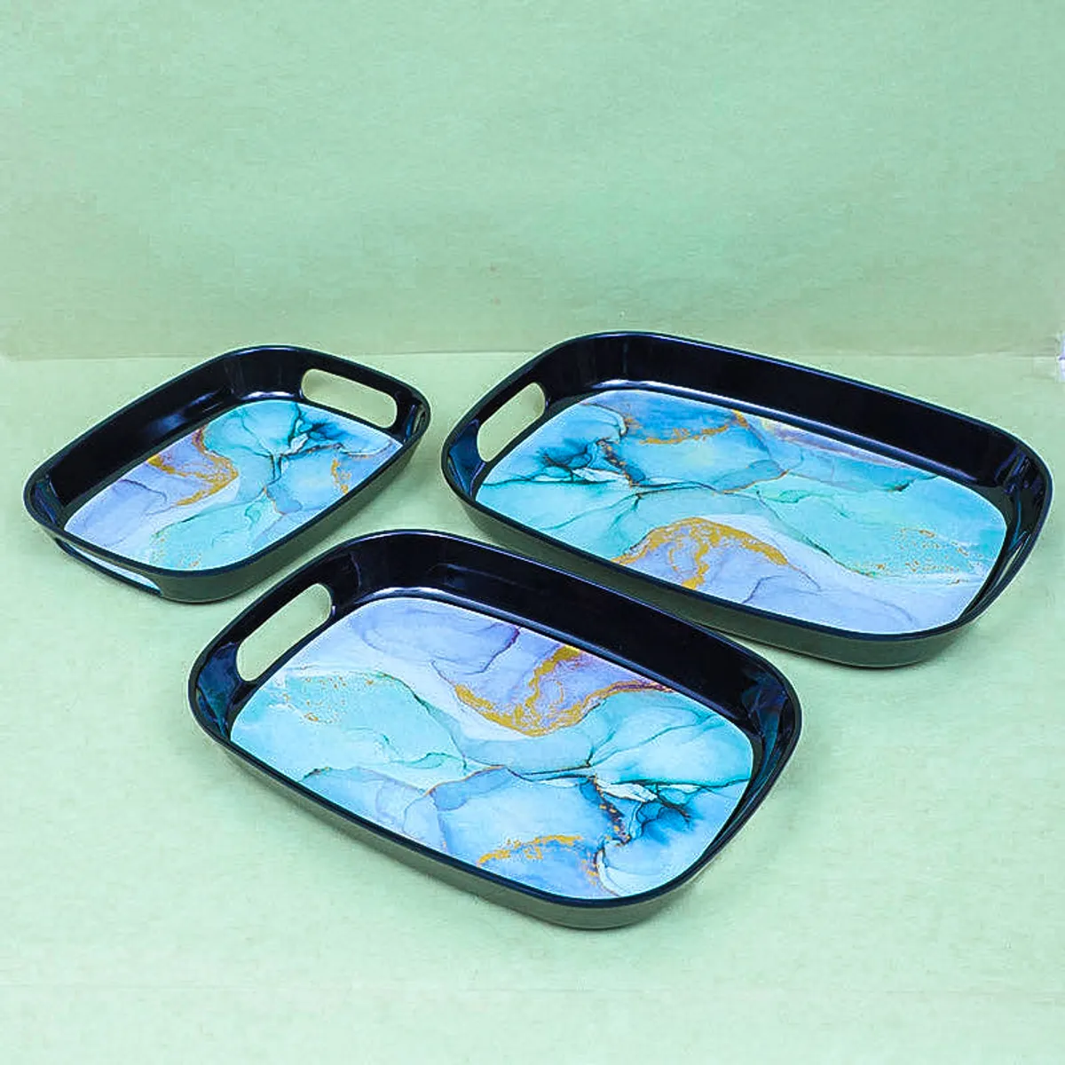 Three blue and gold marbled serving trays arranged in a group