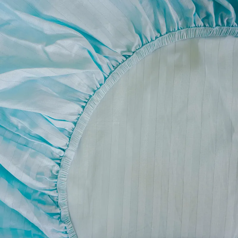 Close-up of elasticated edge on the light blue fitted bedsheet