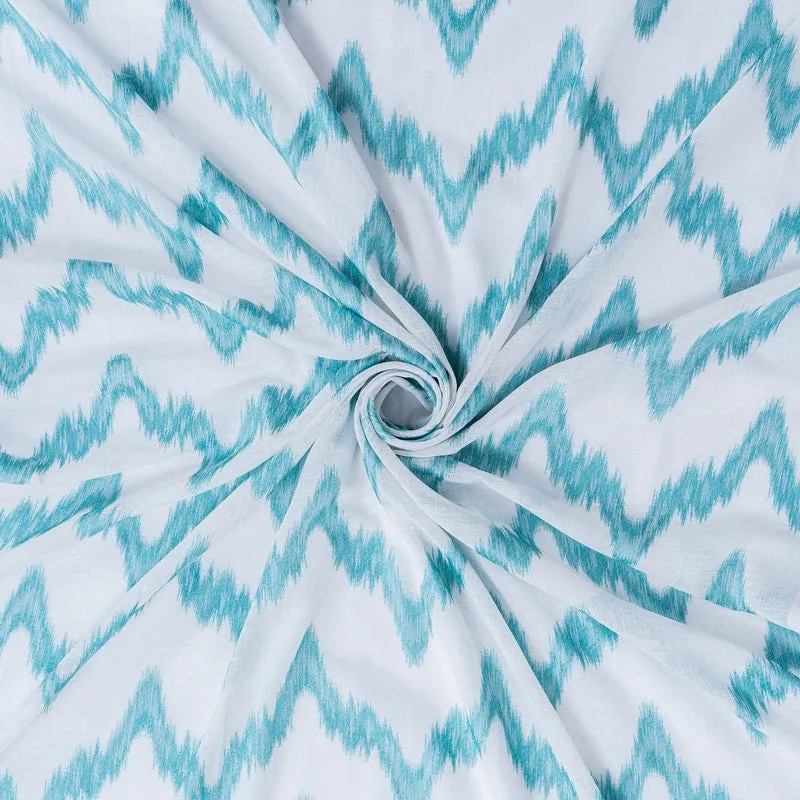 Close-up of lightweight blue and white patterned curtain fabric.