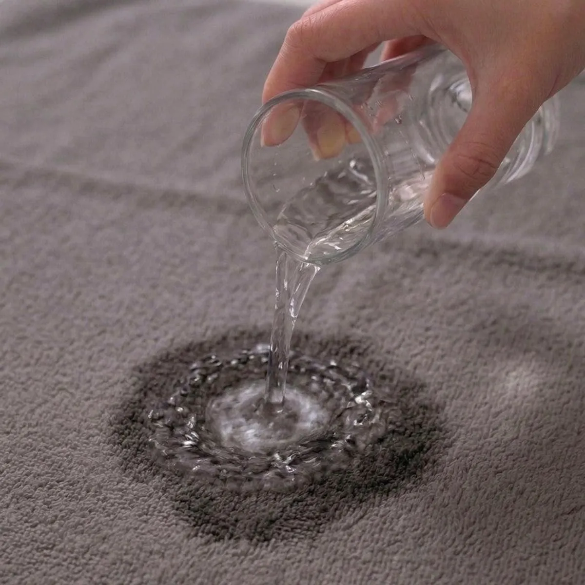 Water being poured onto a grey towel surface