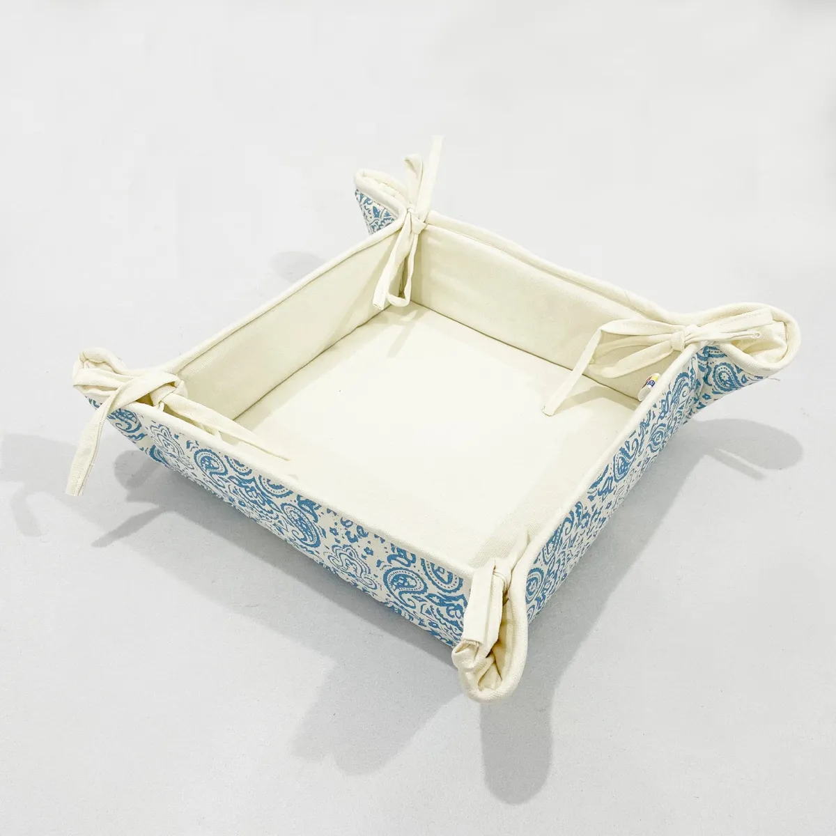 Assembled square bread basket with tied corners and blue paisley exterior