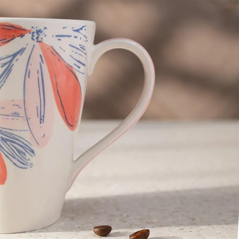 Close-up of the mug's coral and blue floral design and curved handle