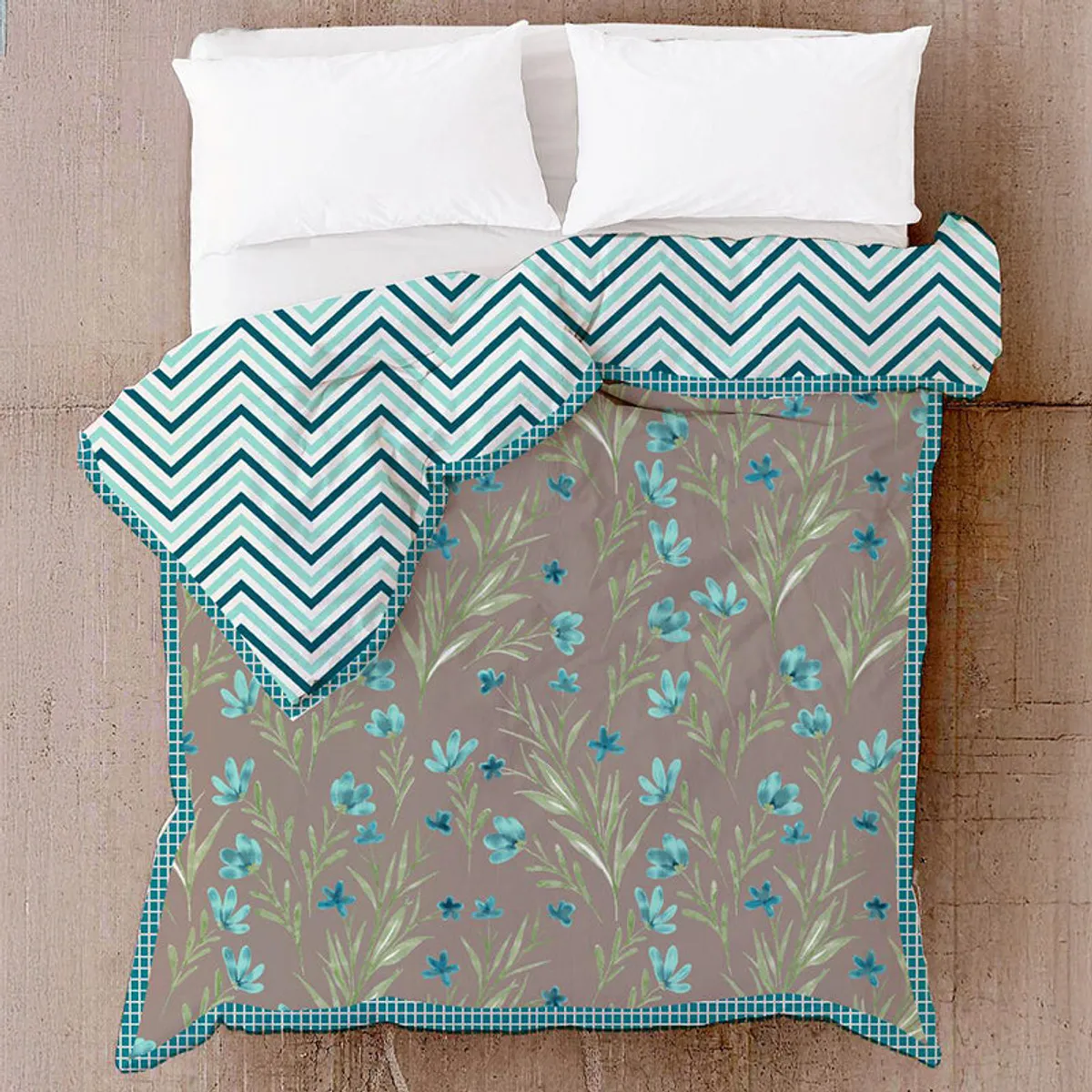 Dohar draped on a bed, showing the floral front, zigzag reverse and checked border.