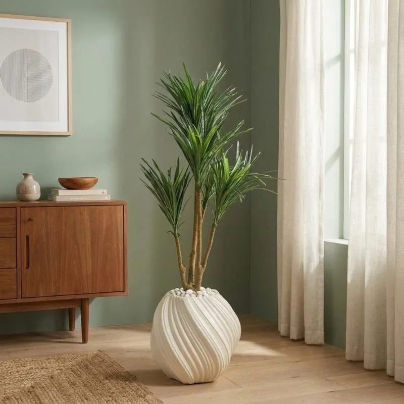White sculptural planter with a tall green plant in a contemporary room