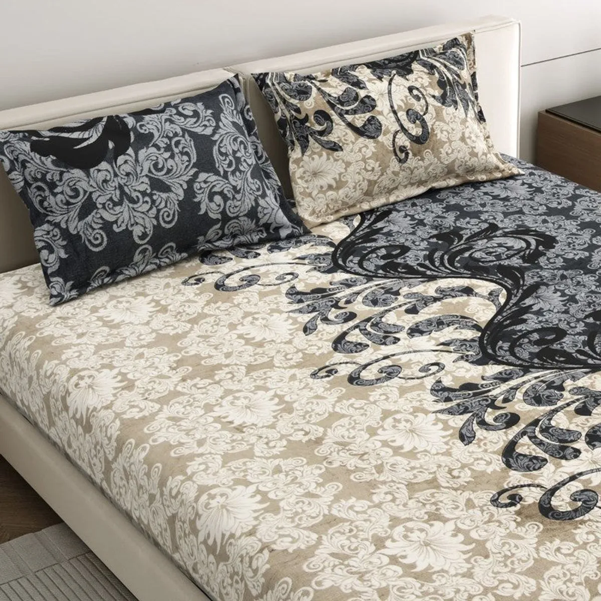 Close view of ornate floral and paisley bedsheet pattern on a bed