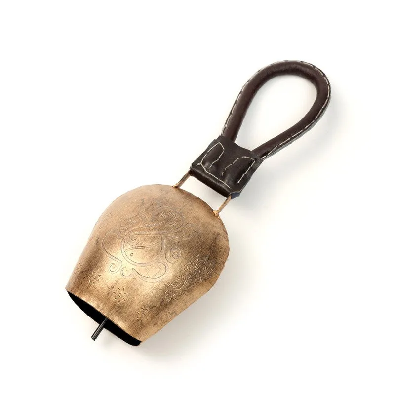 Gold bell lying at an angle, showing its hanging loop and inner clapper