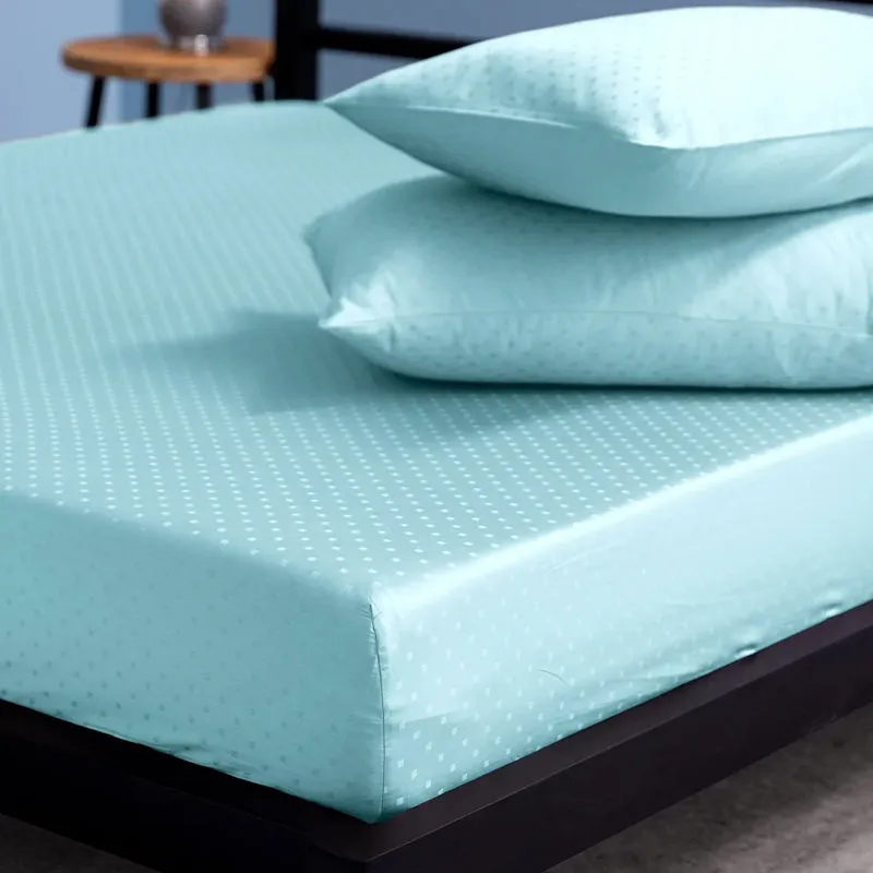 Sky-blue fitted bedsheet corner with matching pillows on a modern bed