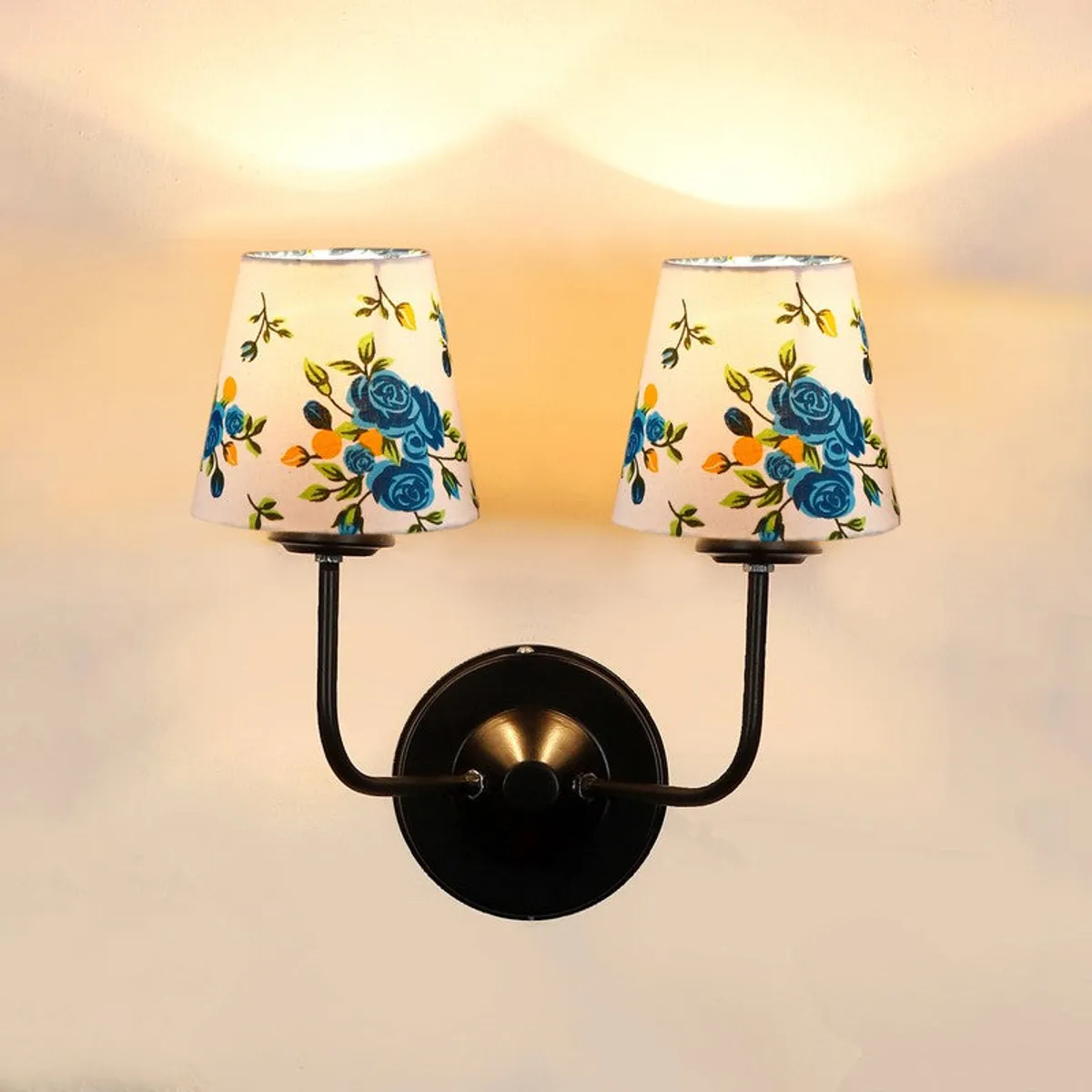 Close view of lit twin wall lamp with two white shades and black base