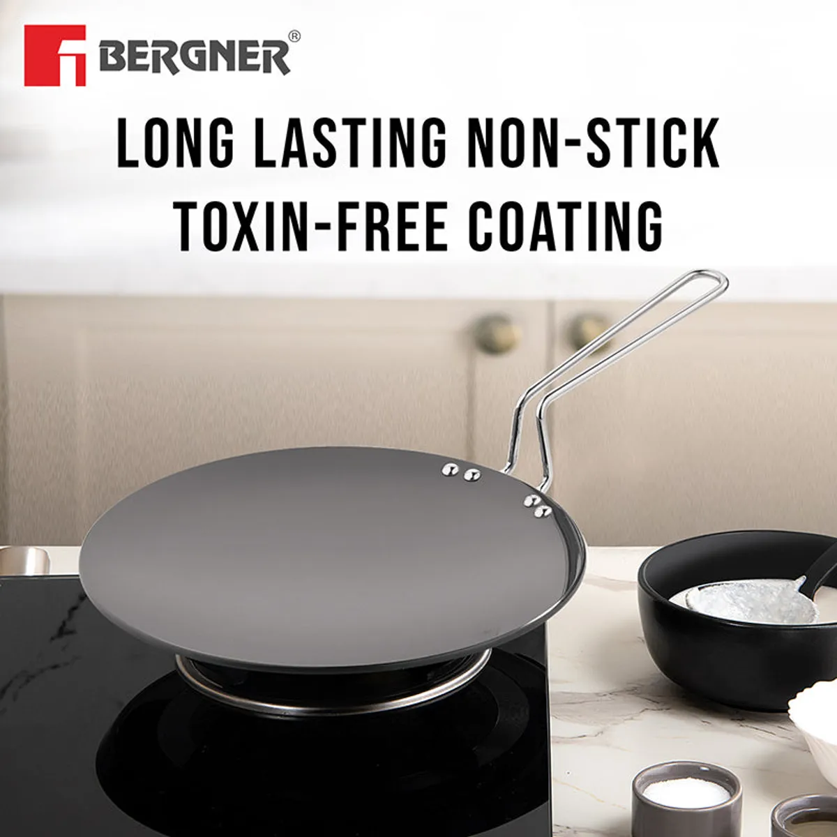 Black round Roti Tawa with a long handle shown in a kitchen setting