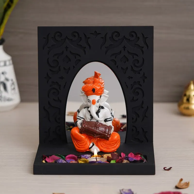 Tea light holder with arched black frame and seated musical Ganesha figure