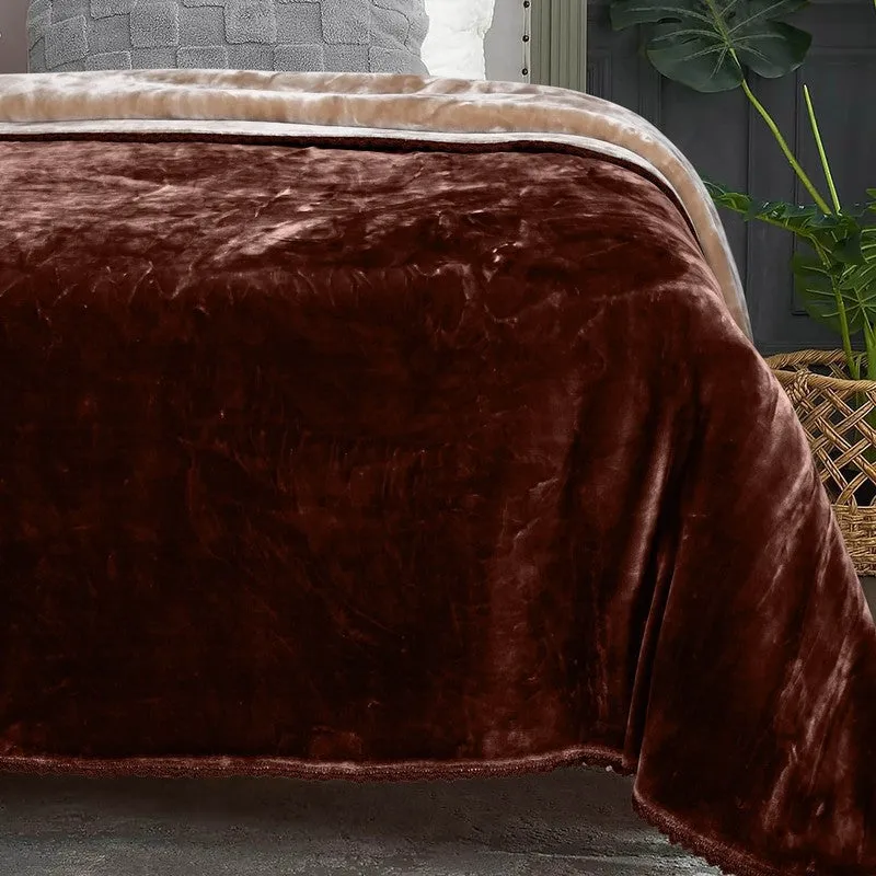 Close-up of the brown plush blanket draped over the side of a bed