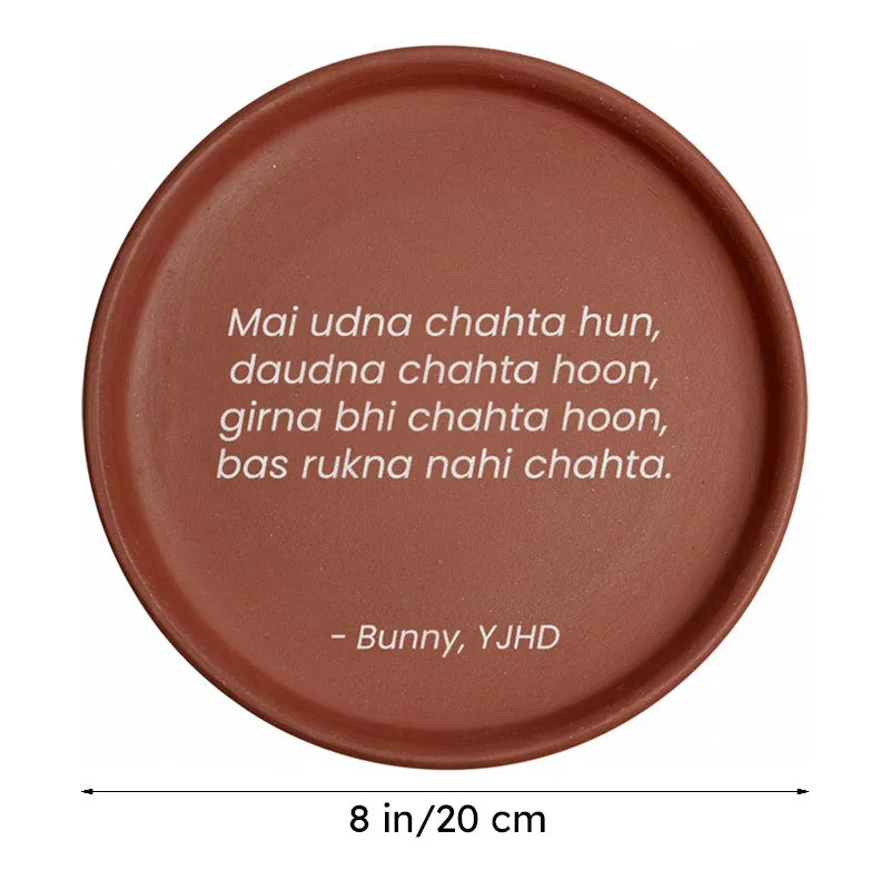 Round brown terracotta wall plate with white quote on white background