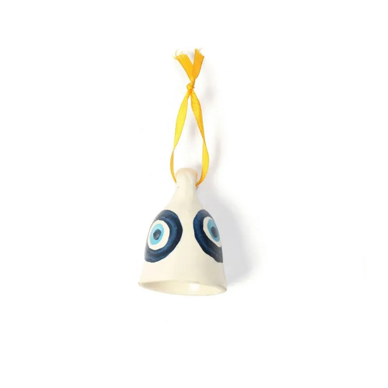 Front view of white ceramic hanging bell with twin blue evil eye motifs and yellow ribbon