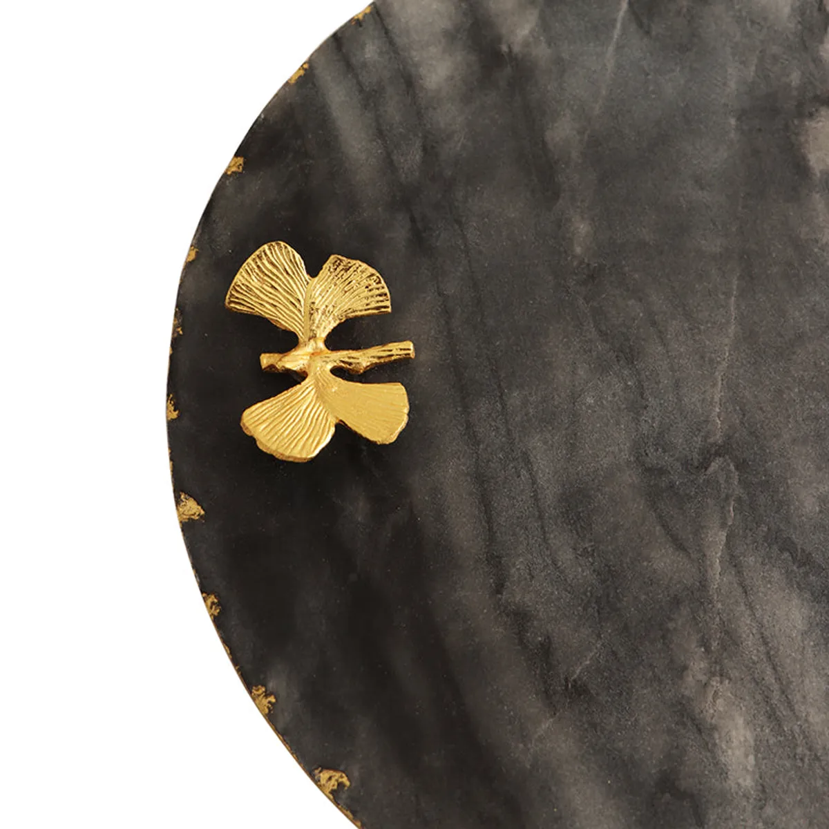 Close-up of the gold butterfly detail on the black marble platter