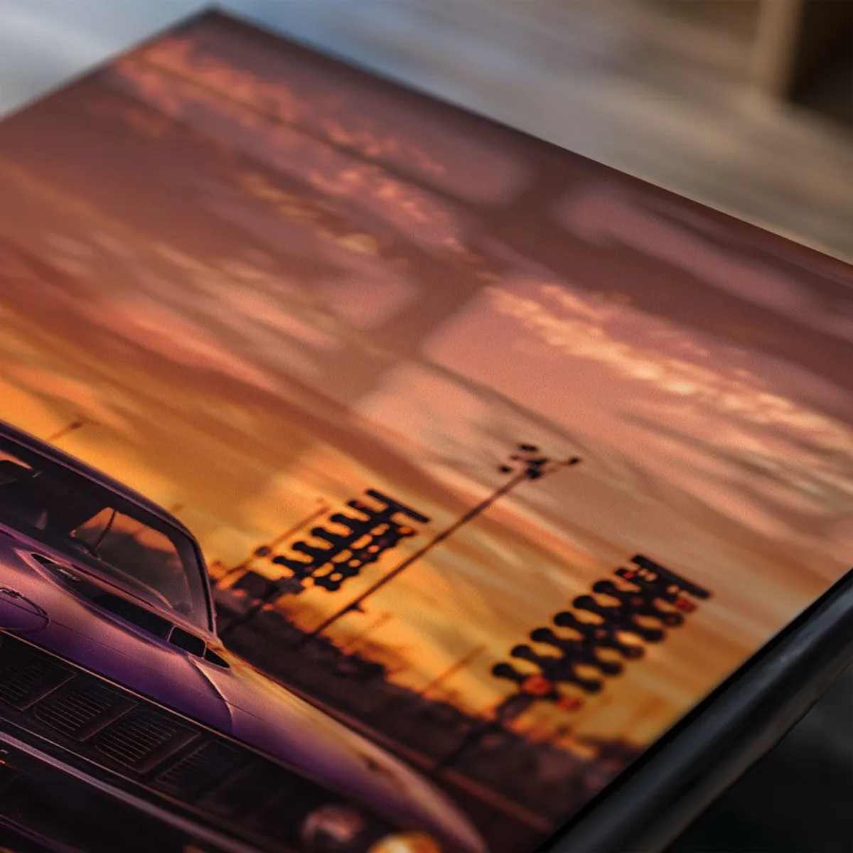 Close-up of a sunset car poster with glossy surface