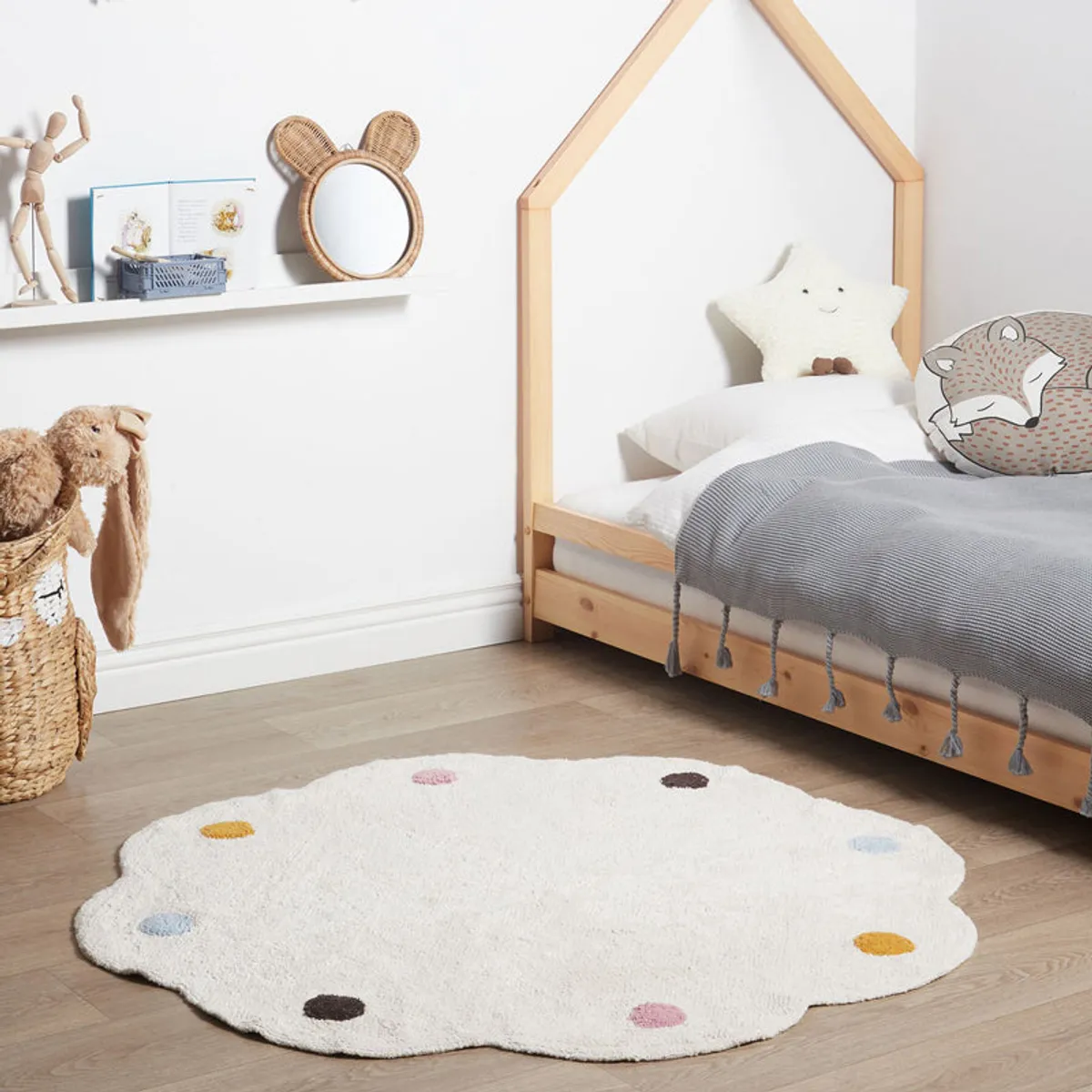 White round tufted rug with scalloped edges and colourful dots in a child's bedroom