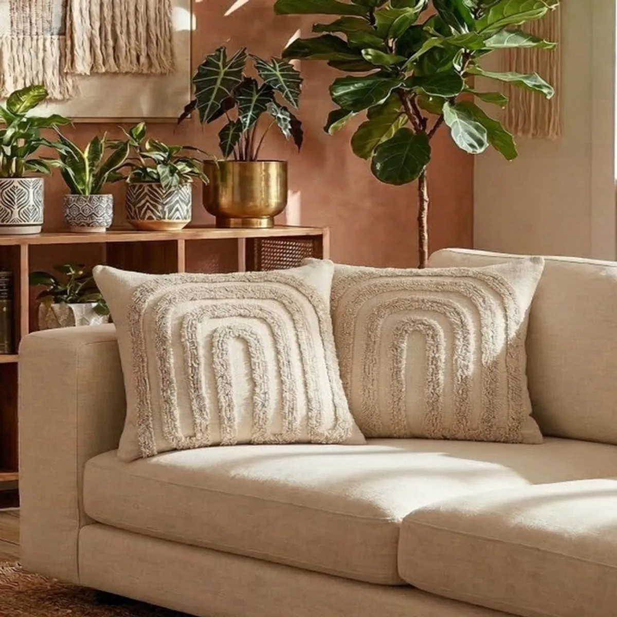 Two off-white tufted cushion covers styled on a neutral sofa among indoor plants.