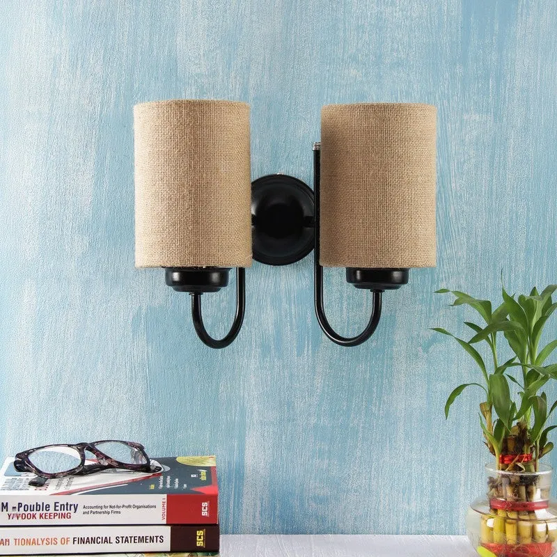 Unlit dual jute wall lamp with black iron frame against a blue wall