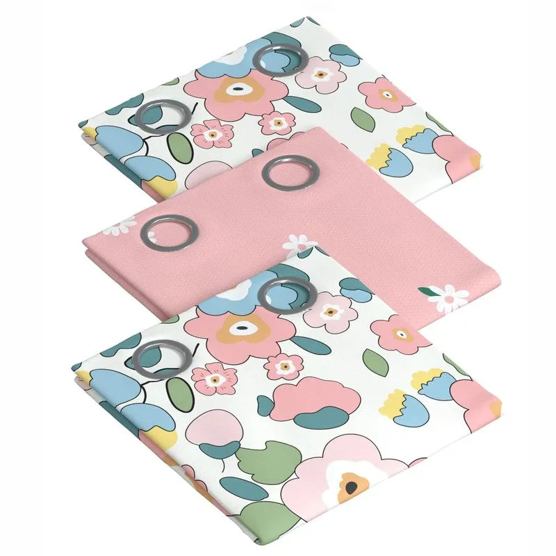 Three folded pink and floral curtain panels with eyelets