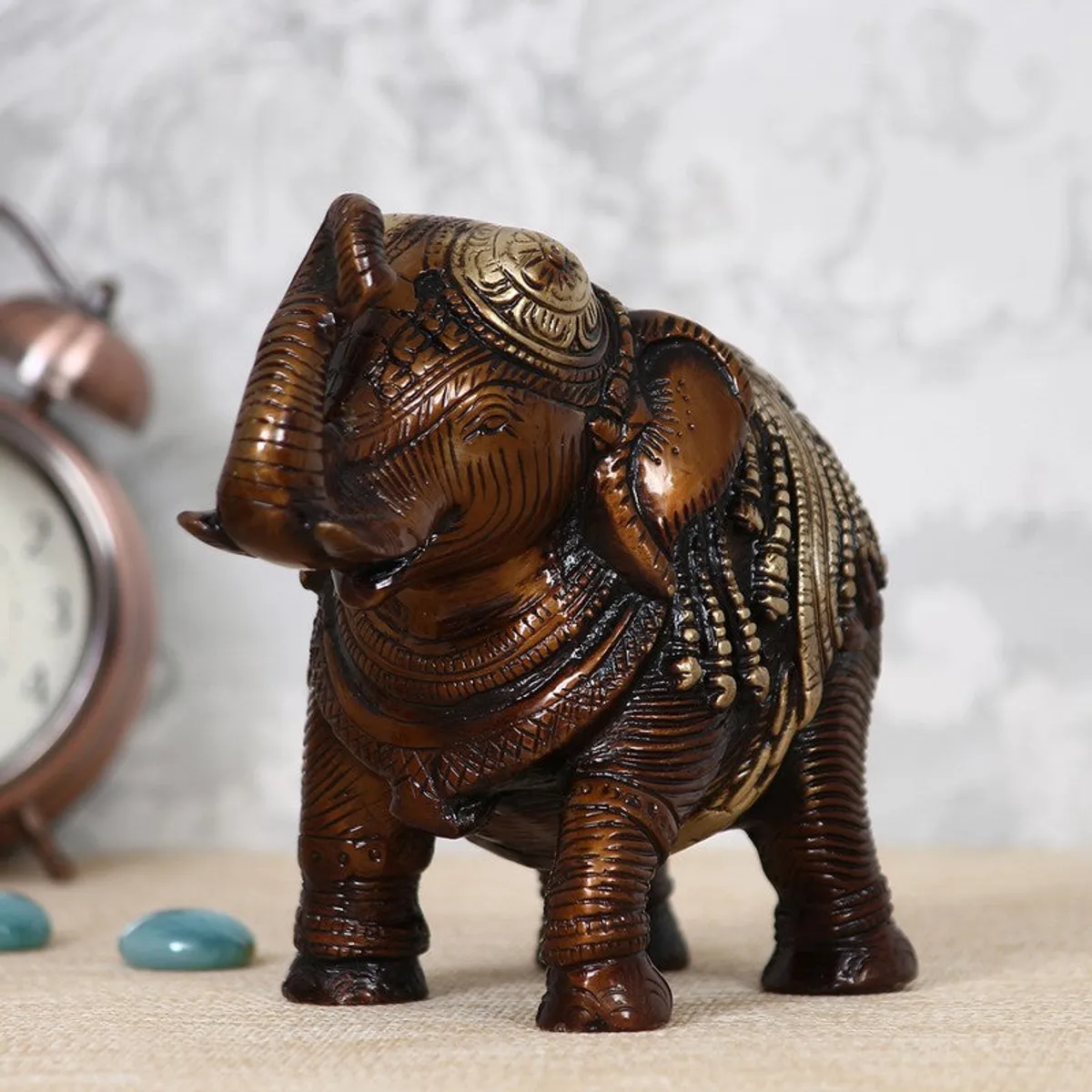Brown elephant figurine with gold detailing and raised trunk