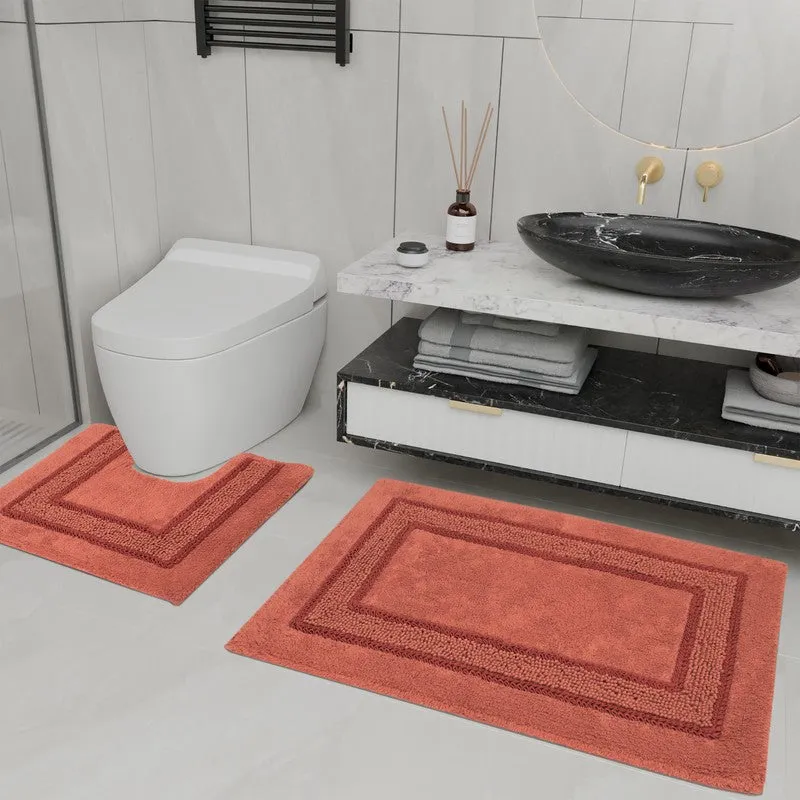 Orange rectangular bath mat and smaller counter mat arranged in a modern bathroom