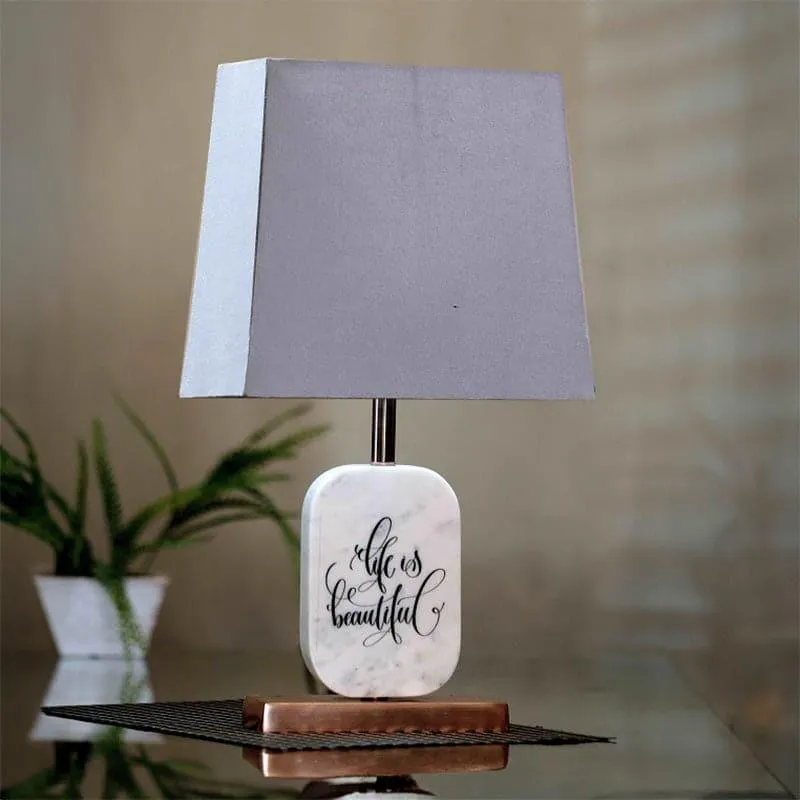 Grey fabric table lamp with white marble base and copper-toned stand