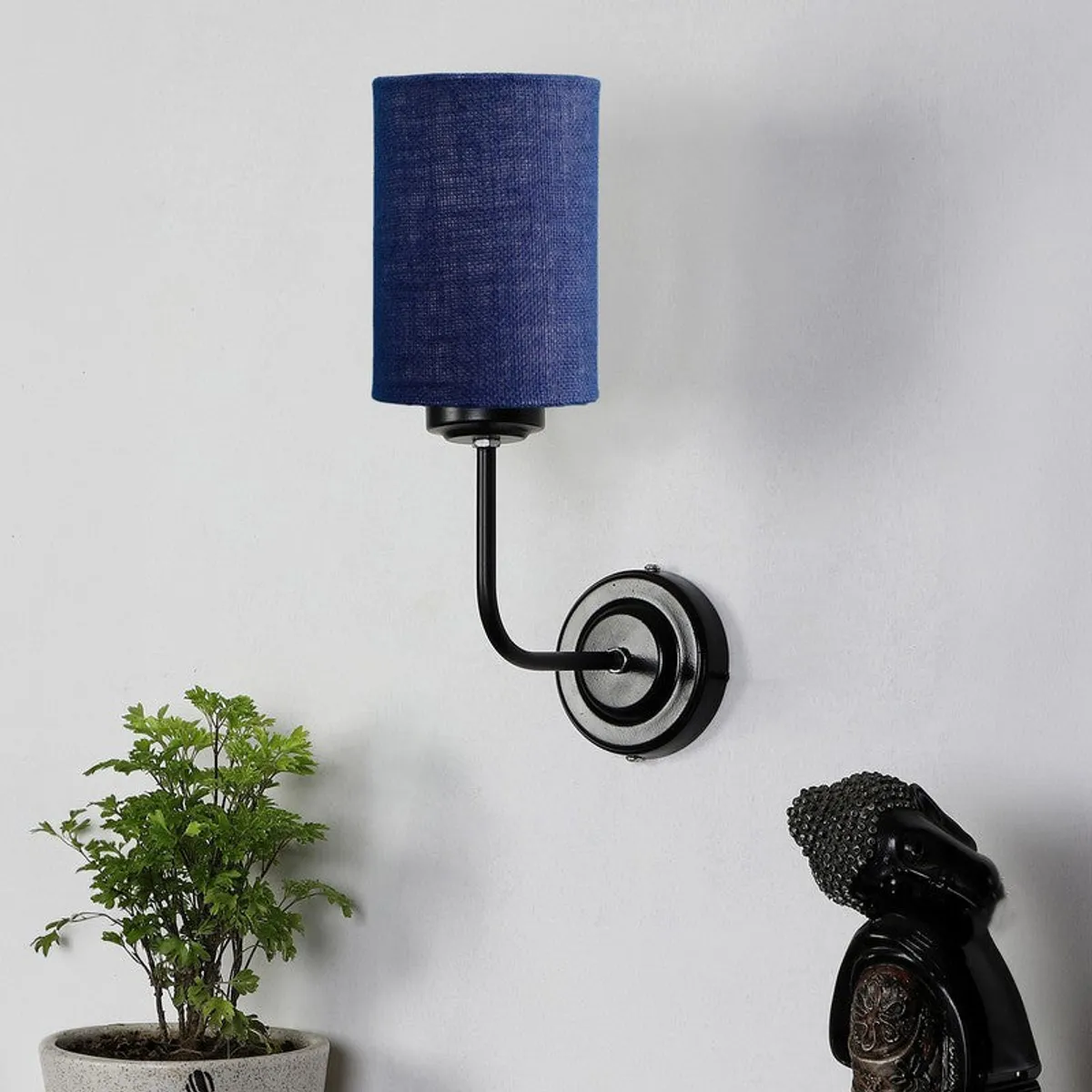 Blue cylindrical wall lamp with black iron arm and round wall plate